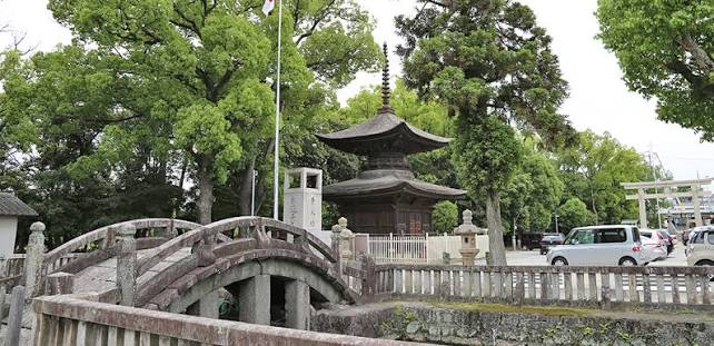 石の太鼓橋と木々に囲まれた多宝塔