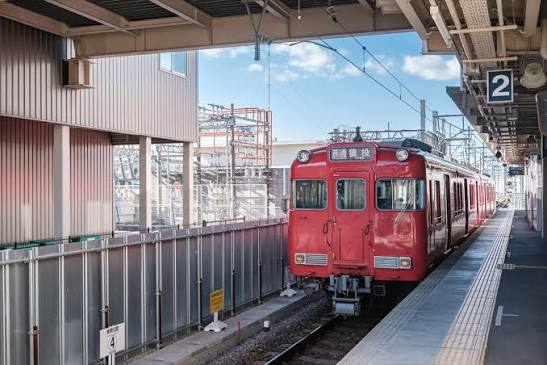 屋根のあるホームに停車する赤い列車