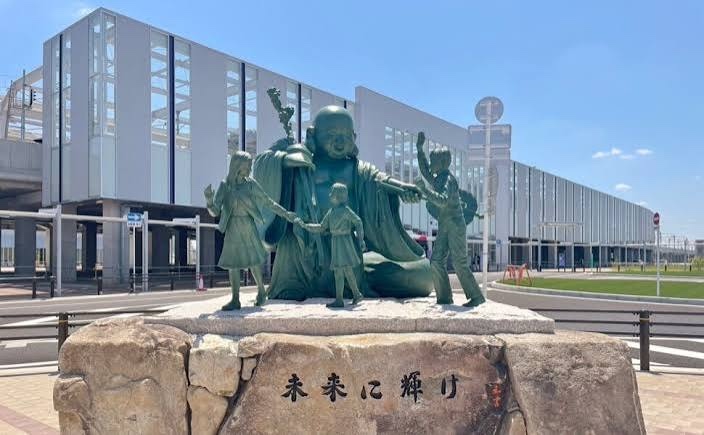 駅前広場に置かれた布袋像と子どもたちの像