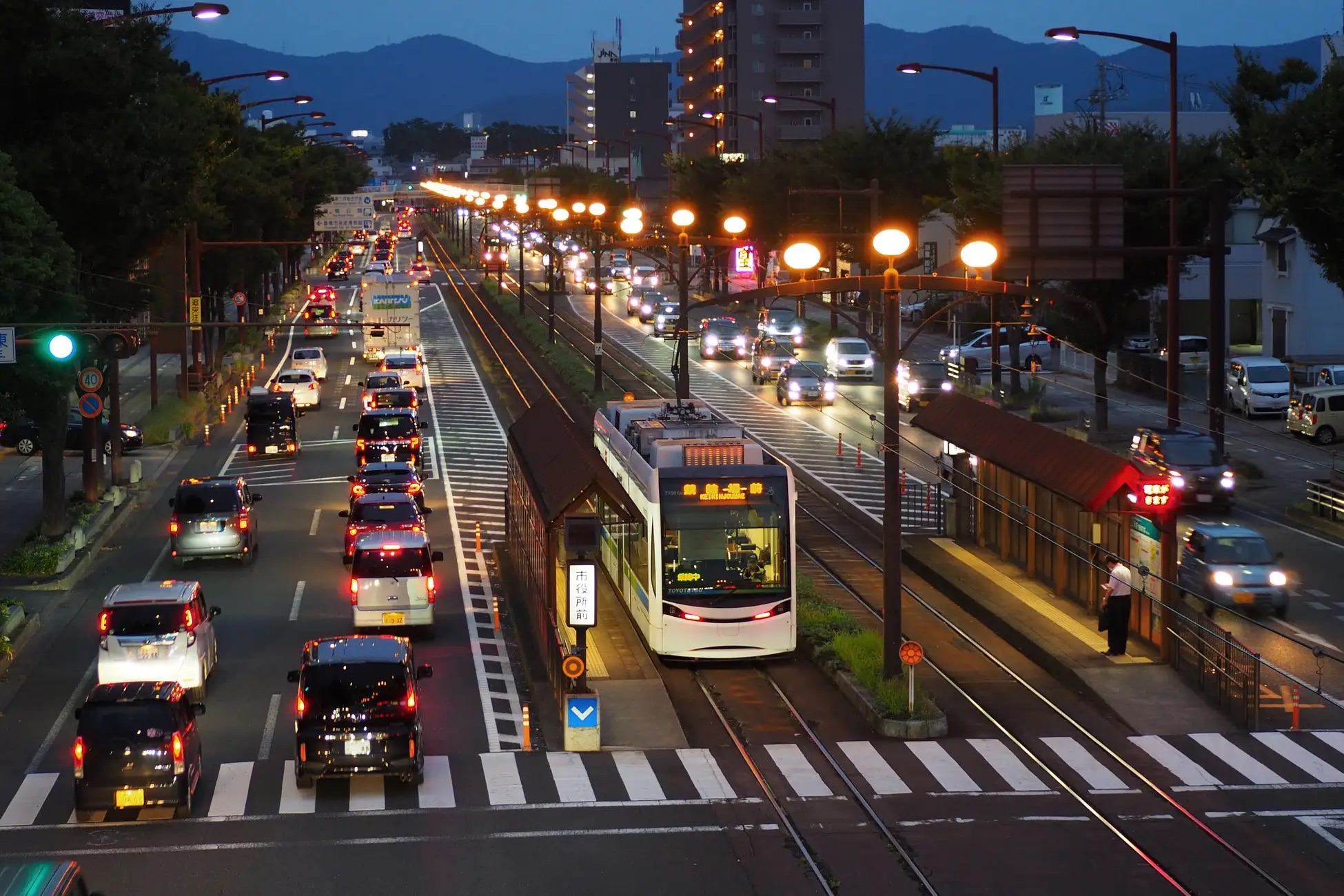 夜の豊橋市内を走る路面電車と市役所前電停